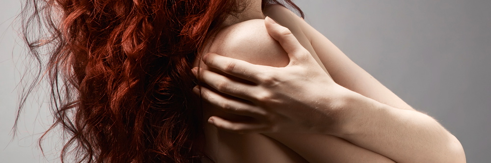 Kvinde rødt hår skjuler bryster
